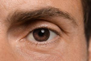 Un hombre con grandes ojos marrones mirando directamente a la cámara.